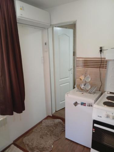 a small kitchen with a stove and a white refrigerator at Villa MIR in Mokra Gora
