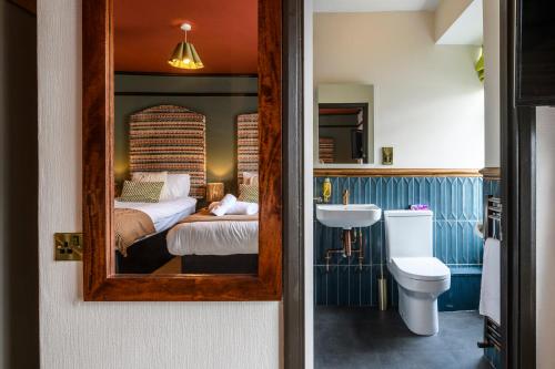 a bathroom with a bed and a sink and a mirror at The Crown Hotel in Lynton