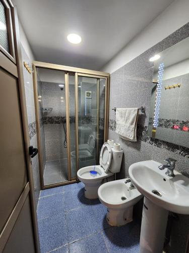 a bathroom with a toilet and a sink and a shower at Residence Imlil Ouarzazate in Ouarzazate