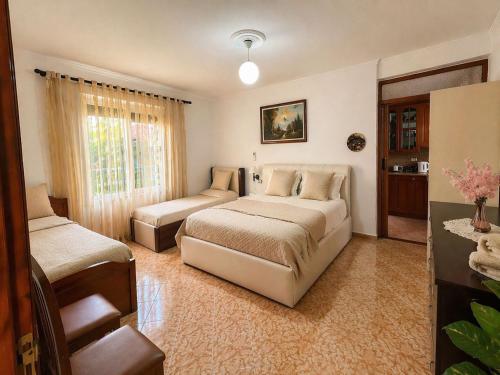 a bedroom with two beds and a couch at Jemin Apartment in Berat
