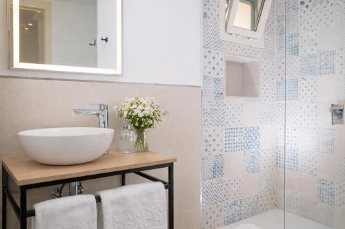 a bathroom with a sink and a glass shower at Aparthotel Marina Drach in Porto Cristo