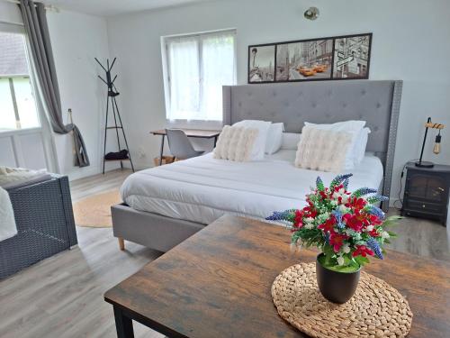 a living room with a bed and a table with flowers at casa de invitados estilo normandie in Chamblac
