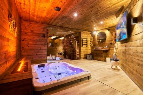a jacuzzi tub in a room with wooden walls at Les cottages du parc in Roubaix
