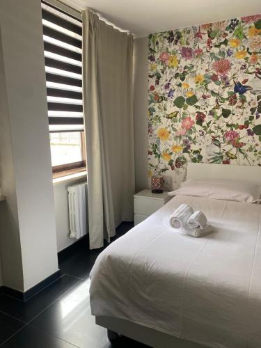 a bedroom with a white bed with a floral wallpaper at La Casa di PAT in Campobasso