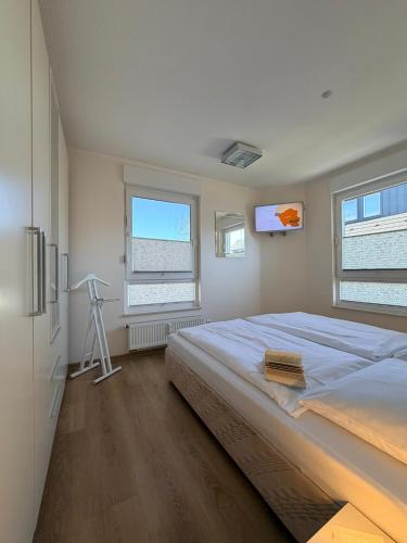 a bedroom with a large bed and a television at Duhner Leuchturm, Ferienwohnung DL02 in Cuxhaven