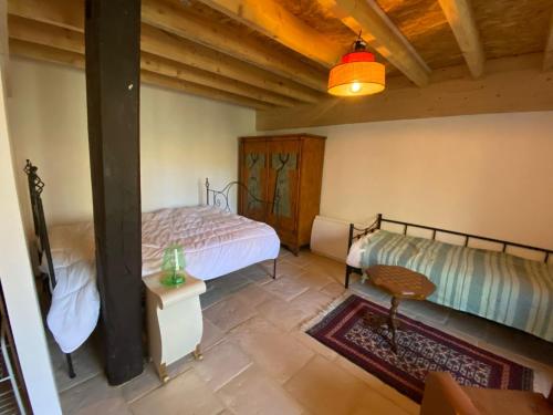 a bedroom with two beds and a table in it at Moulin sous la Vergne in Nanteuil-en-Vallée