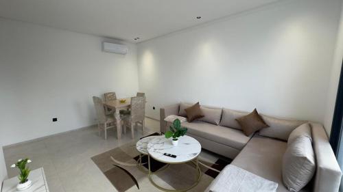 a living room with a couch and a table at Résidence Jasmin in Harqalah