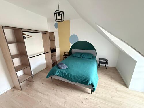 a bedroom with a bed with a green head board at La nouvelle école in Ruillé-en-Champagne