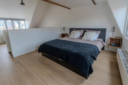 a bedroom with a large bed with a black blanket at BnB 26 in Blankenberge