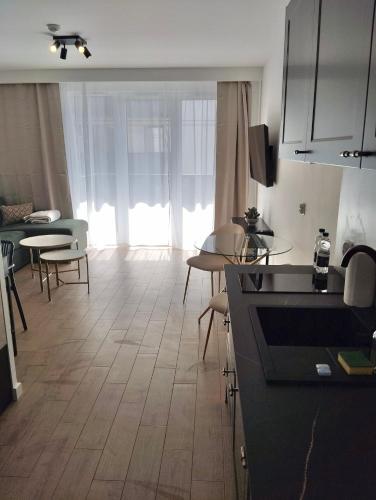 a kitchen and living room with a large window at Amazing Studio Close to Oldtown in Gdańsk
