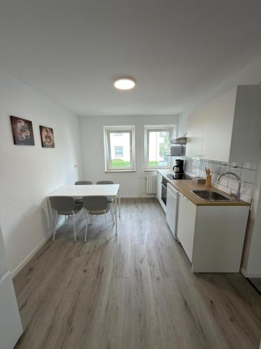 a kitchen with white cabinets and a table and chairs at Ruheblick Apartment Essen in Essen