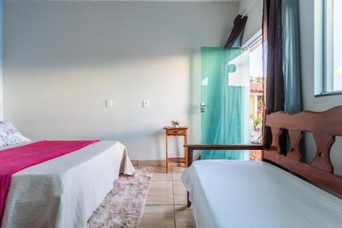a bedroom with two beds and a window at Casa de temporada Âncora dos Sonhos Pirenópolis Goiás in Pirenópolis