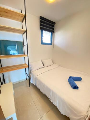 a bedroom with a bed with a ladder and a tv at Pure Bliss Caesarea - אושר טהור בקיסריה in Caesarea