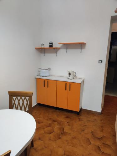 a kitchen with orange cabinets and a white wall at Maison Platone Jolie in Alessandria
