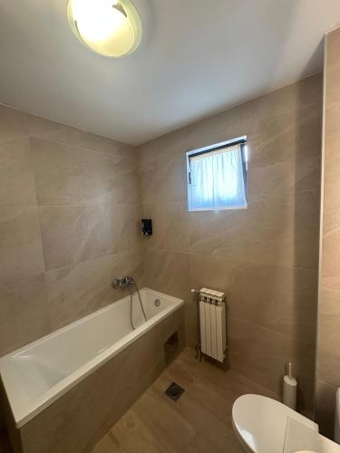 a bathroom with a bath tub and a sink at Grand apartman in Banja Luka