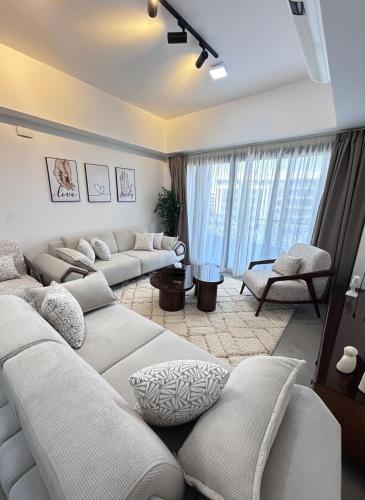 a living room with white couches and a large window at Modern apartment Madinaty in New cairo
