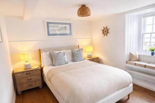 a bedroom with a bed and two lamps and a window at Para Handy Cottage, Inveraray in Inveraray