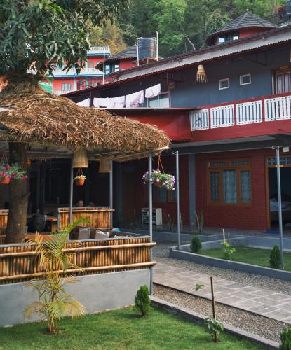un edificio con tetto di paglia e un ristorante di The Mango Tree Backpackers Hostel a Pokhara