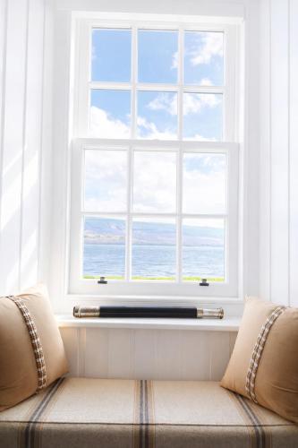 a window in a living room with a couch in front at Para Handy Cottage, Inveraray in Inveraray