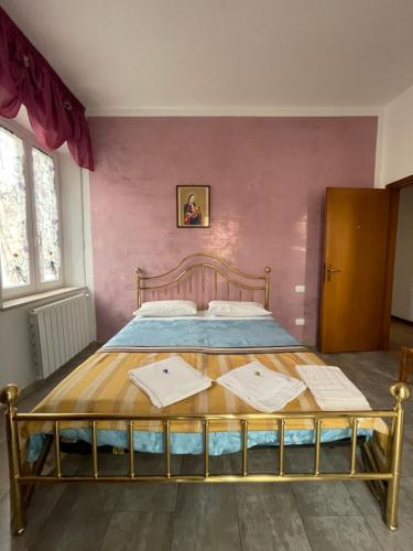 a bedroom with a bed in a pink wall at Le camere del Baldo parcheggio gratuito in centro storico in Peschiera del Garda