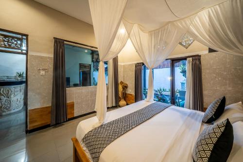 a bedroom with a bed with curtains and windows at Villa Papat Seminyak in Seminyak