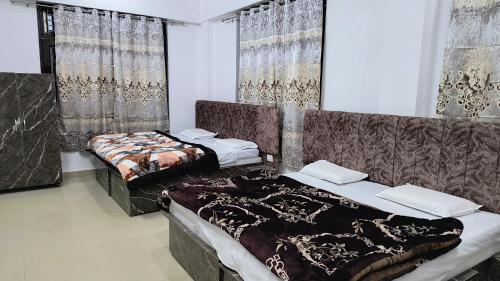 two beds sitting in a room with curtains at Hotel Veerjeet Resorts in Doda