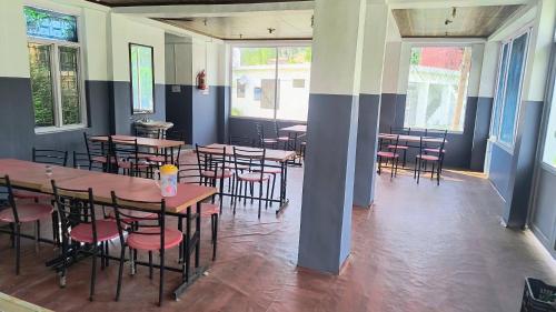 a room with tables and chairs in a restaurant at Hotel Veerjeet Resorts in Doda