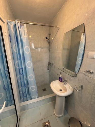a bathroom with a shower and a sink and a mirror at Guest House Ugljevarevic in Budva