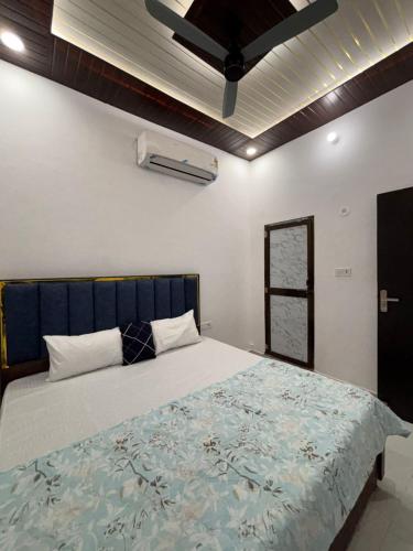 a bedroom with a large bed with a blue headboard at Suryavanshi Guest House in Ayodhya