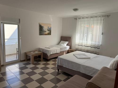a hotel room with two beds and a window at Guest House Ugljevarevic in Budva