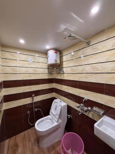 a bathroom with a toilet and a sink at Suryavanshi Guest House in Ayodhya