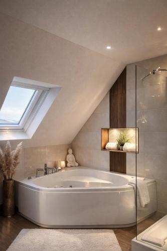 a bath tub in a bathroom with a skylight at Vier Jahreszeiten Hotel in Husum