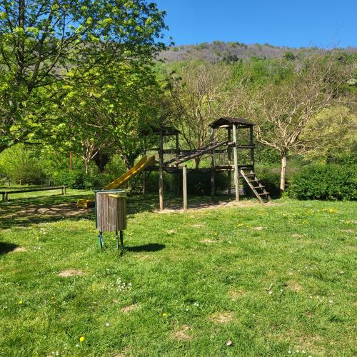 a playground with a slide in a field of grass at Le Pakitoun in Boisse-Penchot