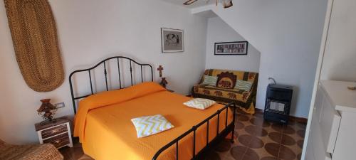 a bedroom with an orange bed and a chair at Iris in Rodio