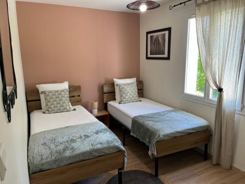 two twin beds in a room with a window at Gîte de Combe Falce in Salignac Eyvigues