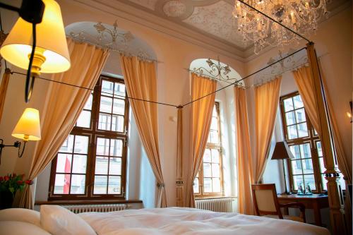 a bedroom with a large bed and windows at Hotel Börse in Görlitz