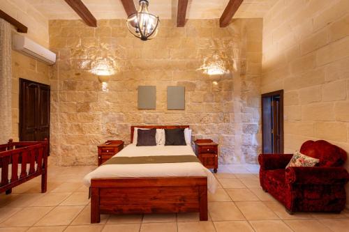 a bedroom with a bed and a chair at Villayana Holiday Home in San Lawrenz