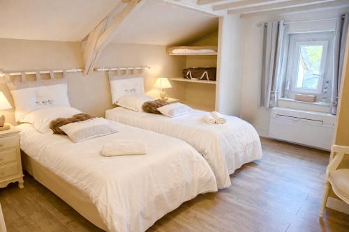a bedroom with two beds and a window at Le Petit Nid de Beauval in Saint-Aignan