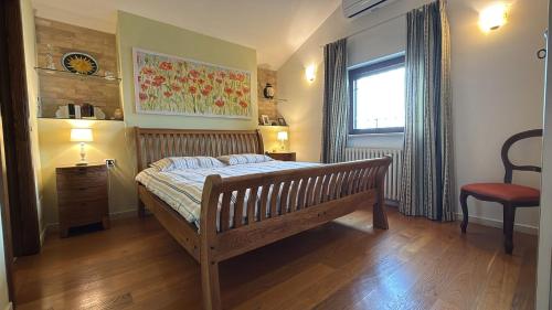 a bedroom with a wooden bed and a window at Casa degli Angeli in Fermo