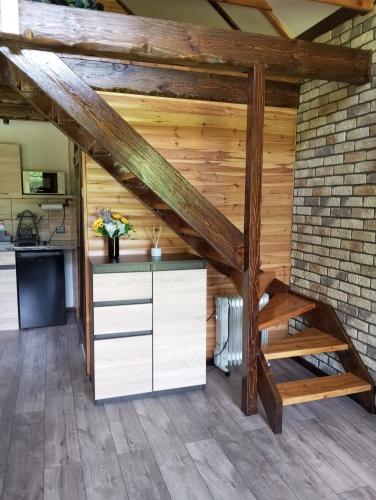 an attic kitchen with wooden beams and a staircase at Olchowym Domek in Gostynin