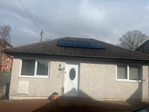 a house with solar panels on the roof at Cute Cottage Central Bathgate Inc Sofa Bed in Bathgate