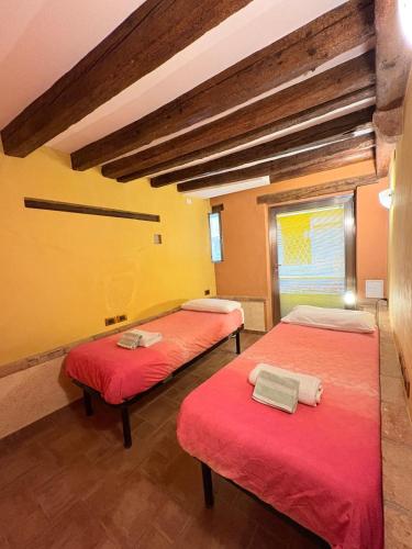 a room with three beds with red sheets at Casa delle gondole in Venice