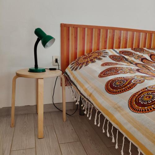 a lamp on a table next to a bed at La Casa del mare in Rosolina Mare