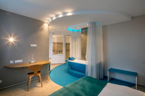 a bedroom with a bed and a bathroom with a tub at Pytloun Imperial Design Suites in Liberec