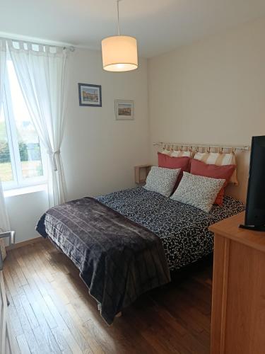 a bedroom with a bed and a tv and a window at Petite maison dans le Morvan in Luzy