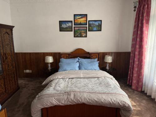 a bedroom with a large bed with blue pillows at Pahuna Homestay in Kathmandu