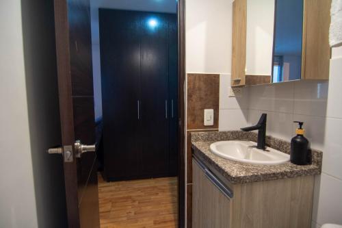 a bathroom with a sink and a black door at Ubicación Privilegiada Torre 2 in Armenia