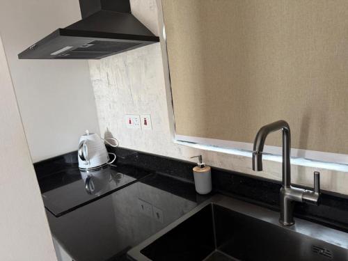 a kitchen with a sink and a mirror above it at 1 Pees Place in Christiansborg