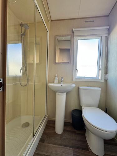 a bathroom with a toilet and a sink and a shower at Kieras View At Bideford Bay in Bideford