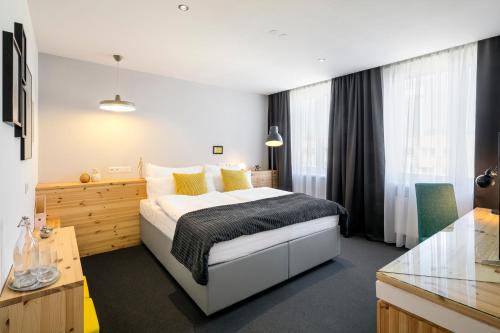 a bedroom with a large bed with yellow pillows at Pytloun Imperial Design Suites in Liberec